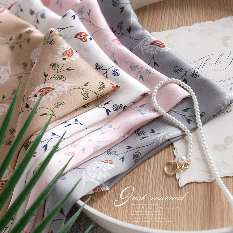 La traducción al español sería: "Pañuelo cuadrado pequeño de estilo coreano con estampado floral primaveral transfronterizo, de alta calidad para mujeres, con sensación de lujo, adecuado para el trabajo diario, hecho de seda artificial impresa."